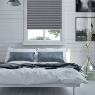 Double divan bed in a light spacious upmarket modern bedroom with large windows and artwork on the walls in grey and white decor